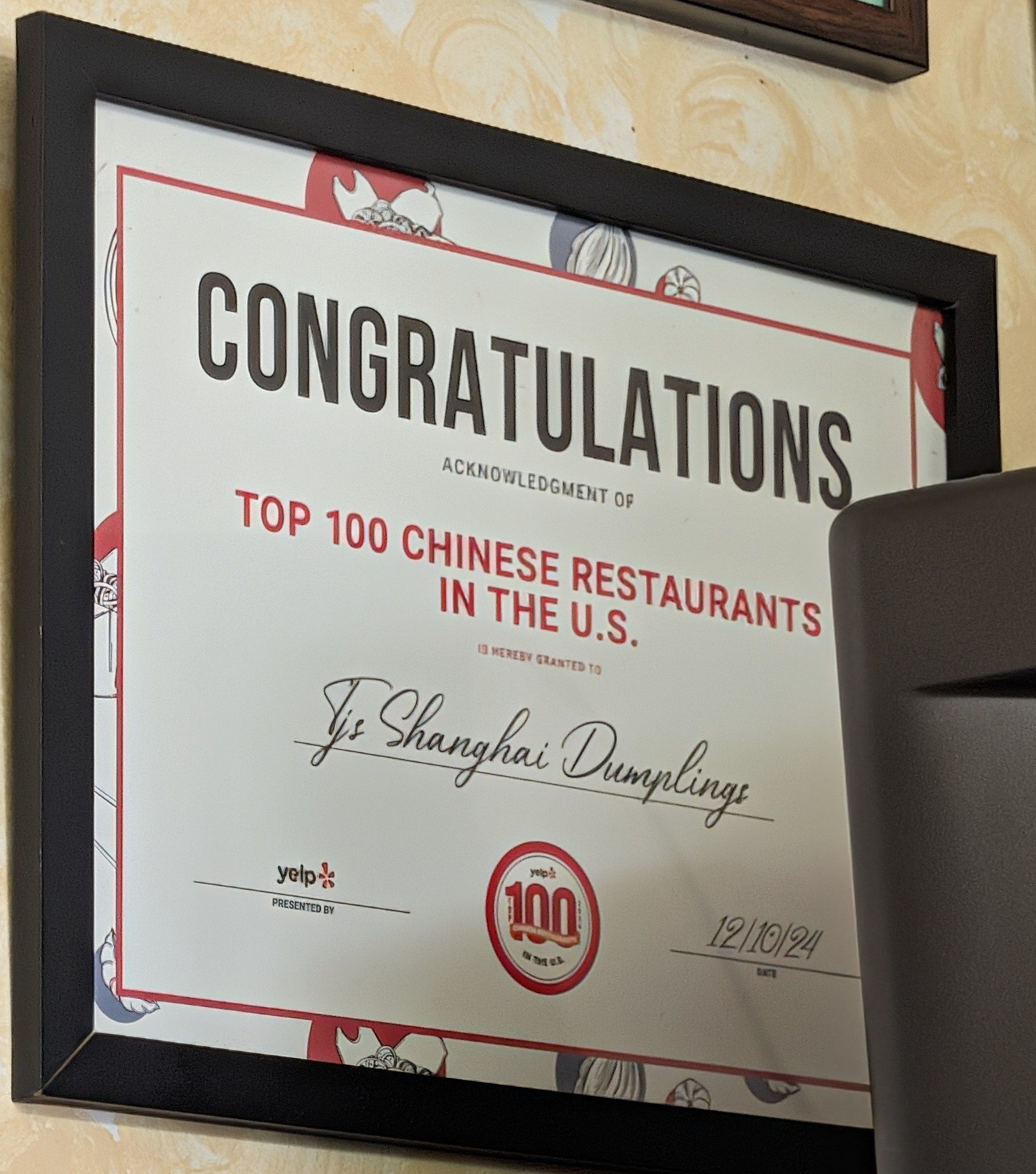 Framed Yelp certificate reading Top 100 Chinese Restaurants in the U.S. granted to TJ's Shanghai Dumplings, dated December 2024